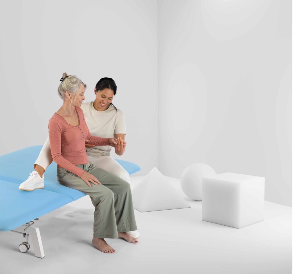 Une personne âgée traitée sur une table Bobath par un physiothérapeute