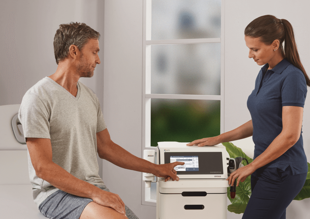 Un physiothérapeute travaillant avec un appareil à ondes de choc